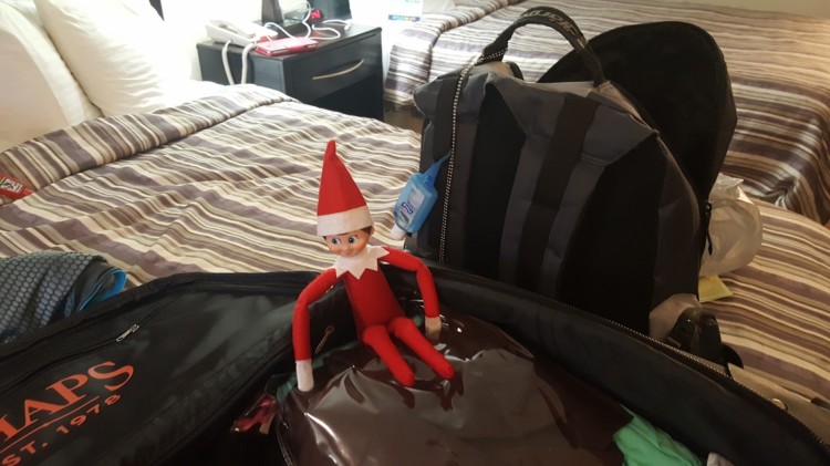 Traveling Elf on the Shelf enjoys a long nap in a suitcase. 