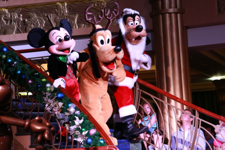 Mickey Mouse, Pluto, and Goofy are dressed in holiday attire to celebrate Christmas at Disney World