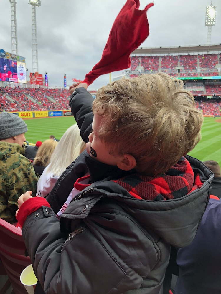 a school-age boy waves a rally towel at Great American Ballpark, during the Cincinnati Reds opening day baseball game