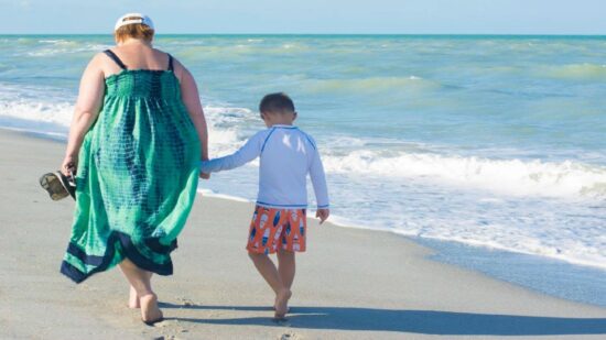 Mom and son walking on a Florida beach
